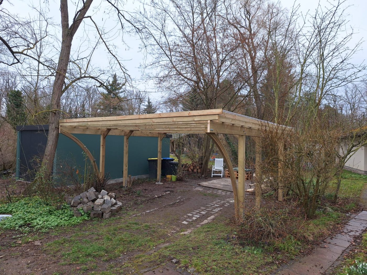Carport aus Holz mit geschwungenen Streben
